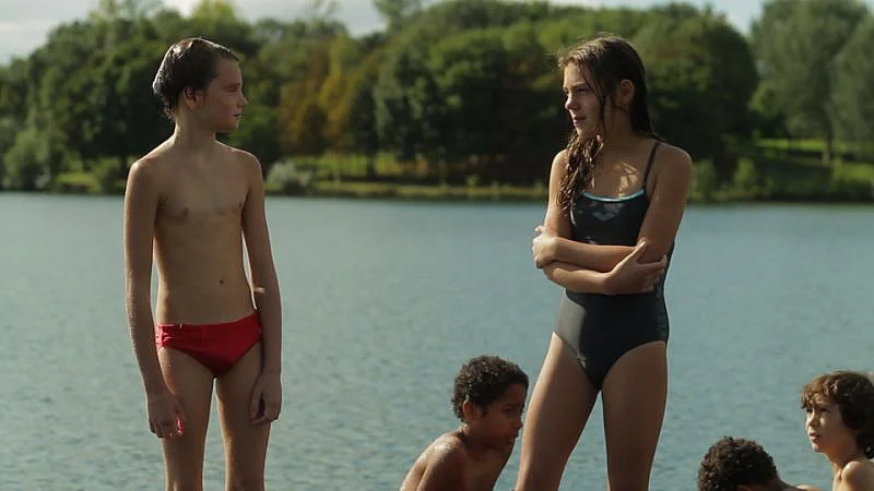 Szenenbild: Laure/Michael in Badehose, neben ihr/ihm ein Mädchen im Badeanzug